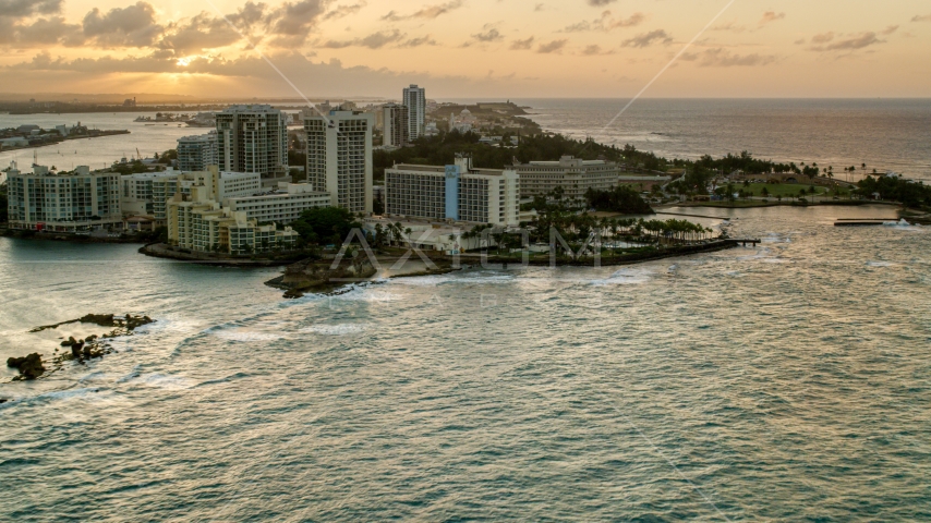 The oceanfront Caribe Hilton Hotel and Normandie Hotel, San Juan, Puerto Rico, sunset Aerial Stock Photo AX104_072.0000000F | Axiom Images