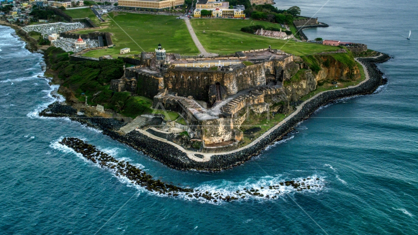 A view of Fort San Felipe del Morro along Caribbean blue waters, Old San Juan, twilight Aerial Stock Photo AX104_084.0000000F | Axiom Images