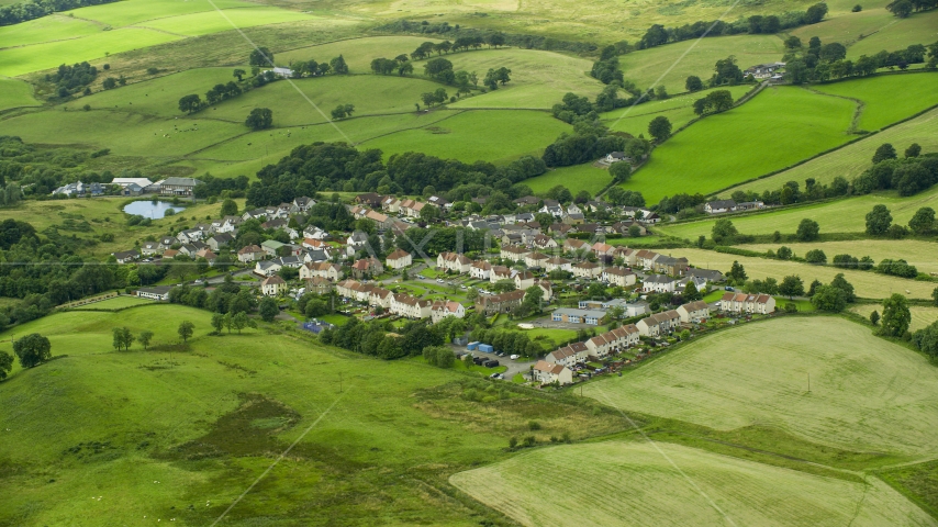 Rural homes surrounded by green fields, Banton, Scotland Aerial Stock Photo AX109_003.0000117F | Axiom Images