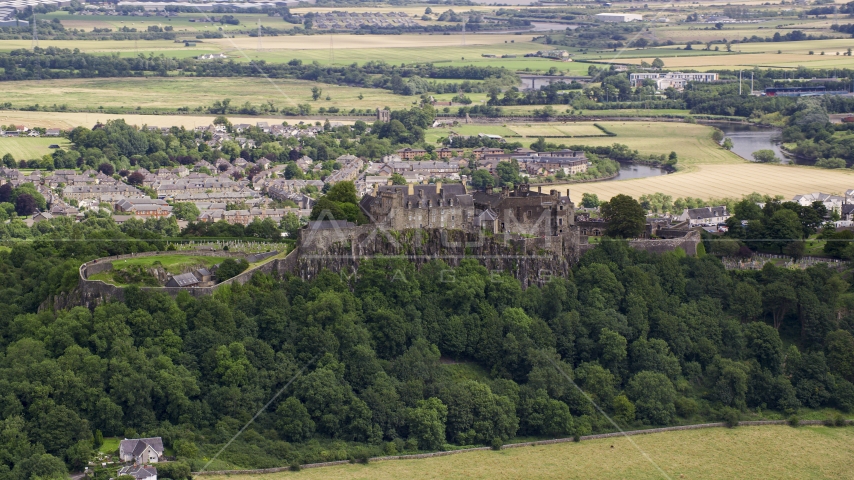 A view of hilltop Stirling Castle among trees, Scotland Aerial Stock Photo AX109_019.0000084F | Axiom Images