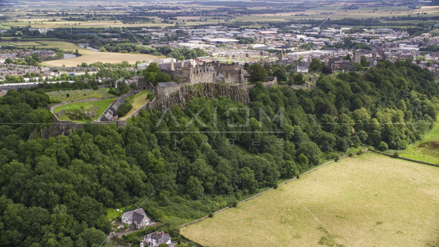 The historic Stirling Castle on a tree covered hill, Scotland Aerial Stock Photo AX109_024.0000000F | Axiom Images