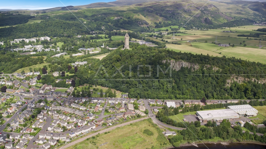 The historic Wallace Monument on a hill with trees, Stirling, Scotland Aerial Stock Photo AX109_047.0000064F | Axiom Images