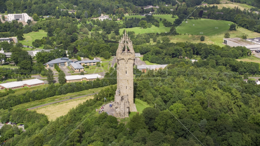 The historic Wallace Monument on a tree-covered hill, Stirling, Scotland Aerial Stock Photo AX109_049.0000000F | Axiom Images