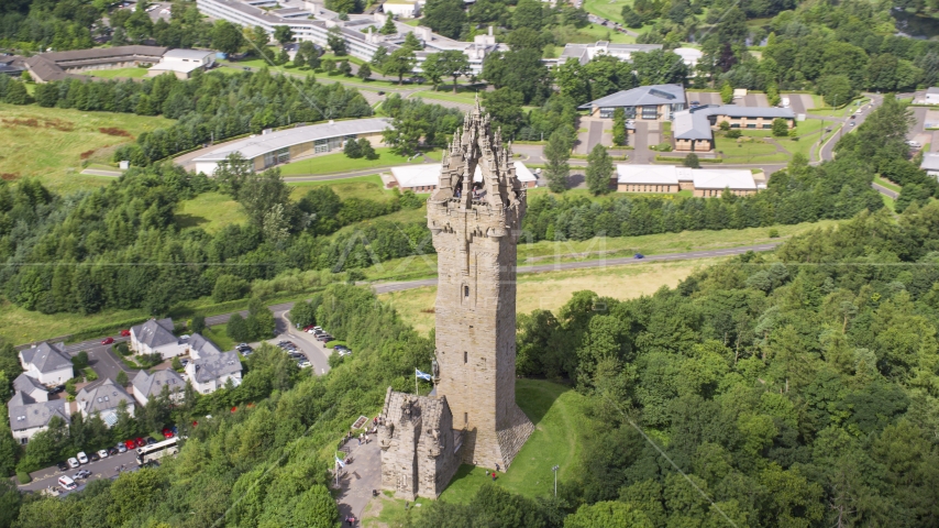 Iconic Wallace Monument on a tree-covered hill, Stirling, Scotland Aerial Stock Photo AX109_049.0000143F | Axiom Images