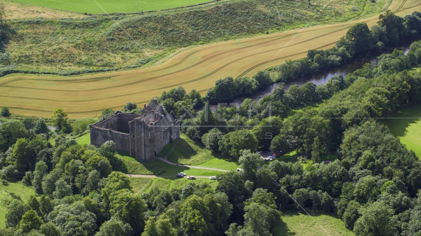 Historic Doune Castle beside a river in Scotland Aerial Stock Photo AX109_066.0000137F | Axiom Images