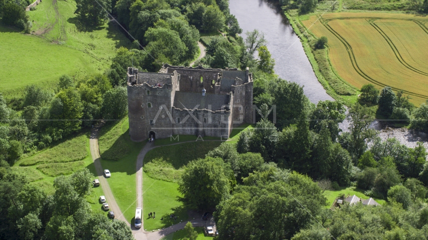 Historic Doune Castle beside a river, Scotland Aerial Stock Photo AX109_068.0000123F | Axiom Images