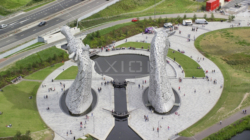The Kelpies sculptures with tourists in Falkirk, Scotland Aerial Stock Photo AX109_126.0000000F | Axiom Images