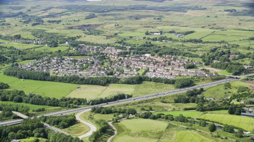 Farm fields and highway M80 by rural village homes, Bonnybridge, Scotland Aerial Stock Photo AX109_172.0000093F | Axiom Images
