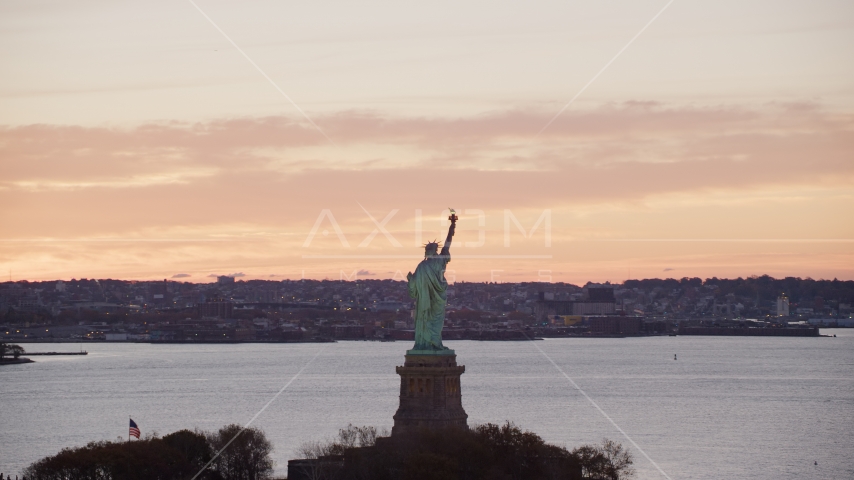 Statue of Liberty with a view of Brooklyn at sunrise, New York Aerial Stock Photo AX118_041.0000196F | Axiom Images
