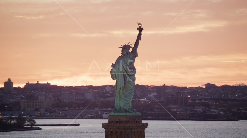 Statue of Liberty with a view of Brooklyn at sunrise, New York Aerial Stock Photo AX118_042.0000000F | Axiom Images