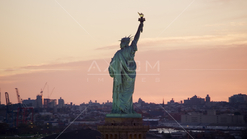 Behind the Statue of Liberty at sunrise, New York Aerial Stock Photo AX118_042.0000234F | Axiom Images