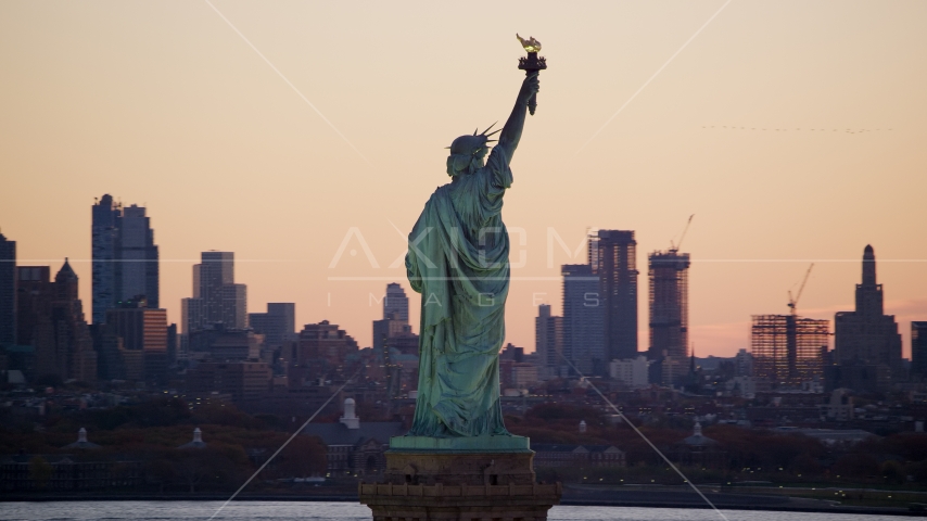 Statue of Liberty and Brooklyn skyline at sunrise, New York Aerial Stock Photo AX118_043.0000107F | Axiom Images