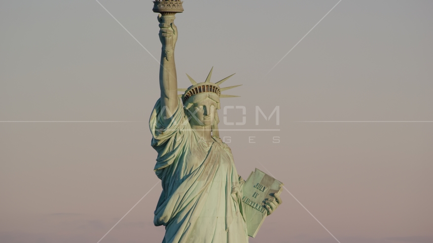 The front of the Statue of Liberty at sunrise in New York Aerial Stock Photo AX118_107.0000082F | Axiom Images