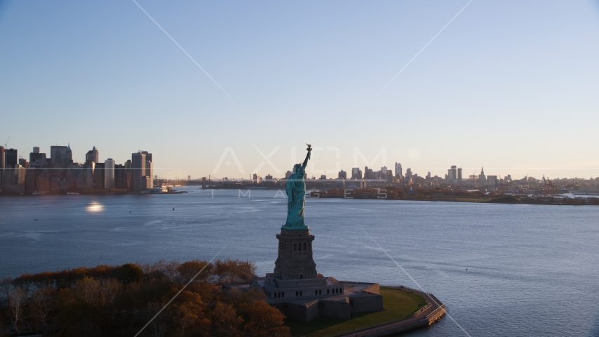 Statue of Liberty with Brooklyn in the background at sunrise in New York Aerial Stock Photo AX118_118.0000000F | Axiom Images