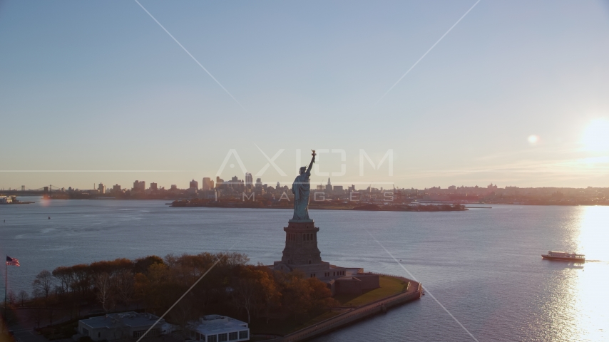 Statue of Liberty and Brooklyn across the harbor at sunrise in New York Aerial Stock Photo AX118_118.0000187F | Axiom Images