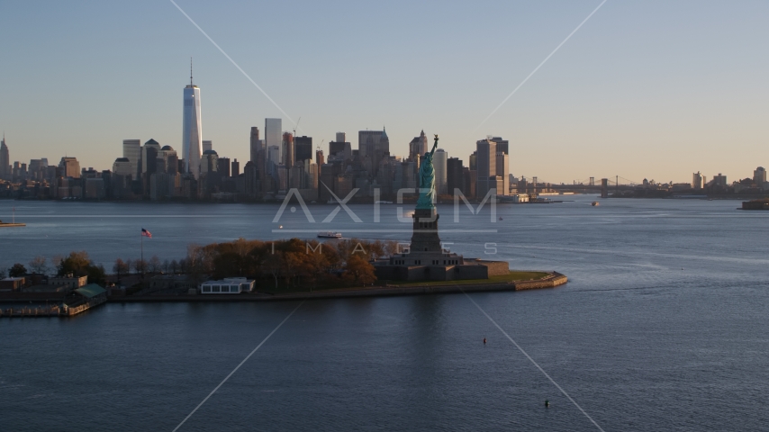 Statue of Liberty and Lower Manhattan skyline at sunrise in New York Aerial Stock Photo AX118_122.0000000F | Axiom Images