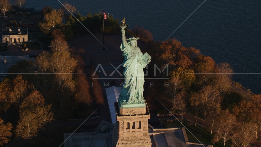 Statue of Liberty and autumn trees at sunrise in New York Aerial Stock Photo AX118_146.0000077F | Axiom Images