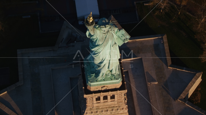 Bird's eye view of the Statue of Liberty at sunrise in New York Aerial Stock Photo AX118_147.0000104F | Axiom Images