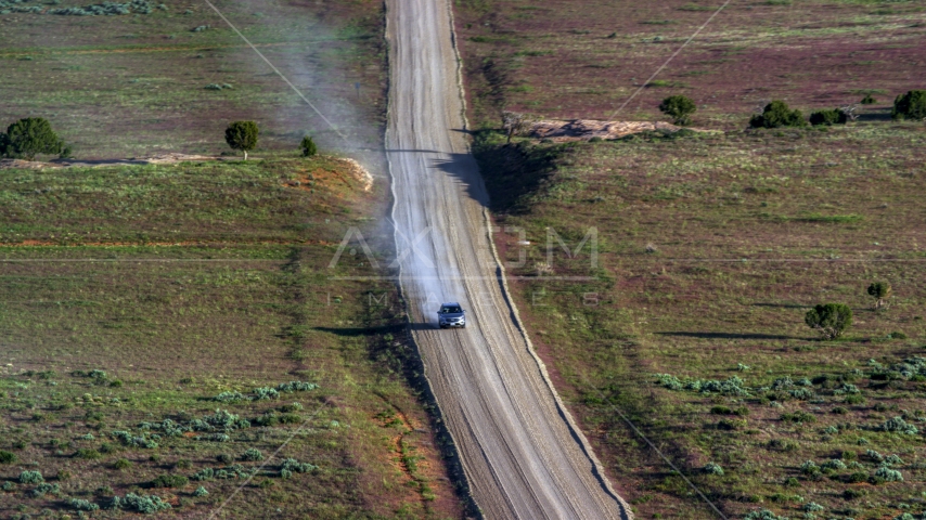 A silver SUV leaving a trail of dust on Hatch Point Road, Moab, Utah Aerial Stock Photo AX138_223.0000041 | Axiom Images
