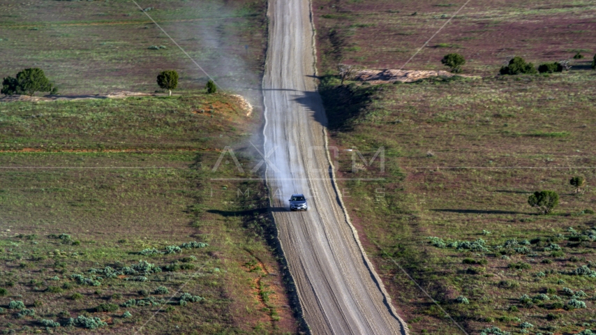 Silver SUV trailing a plume of dust on Hatch Point Road, Moab, Utah Aerial Stock Photo AX138_223.0000047 | Axiom Images