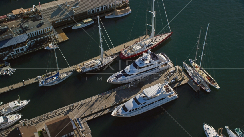 Two yachts docked near sailboats at piers in Newport, Rhode Island Aerial Stock Photo AX144_238.0000119 | Axiom Images