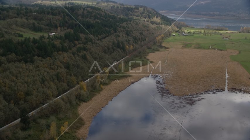 A train traveling by fields and water in Washougal, Washington Aerial Stock Photo AX153_178.0000113F | Axiom Images