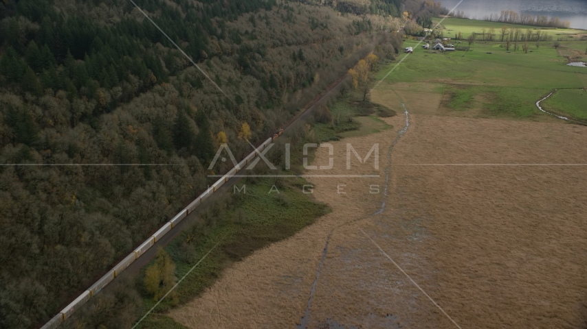 A train traveling by fields and water in Washougal, Washington Aerial Stock Photo AX153_178.0000352F | Axiom Images