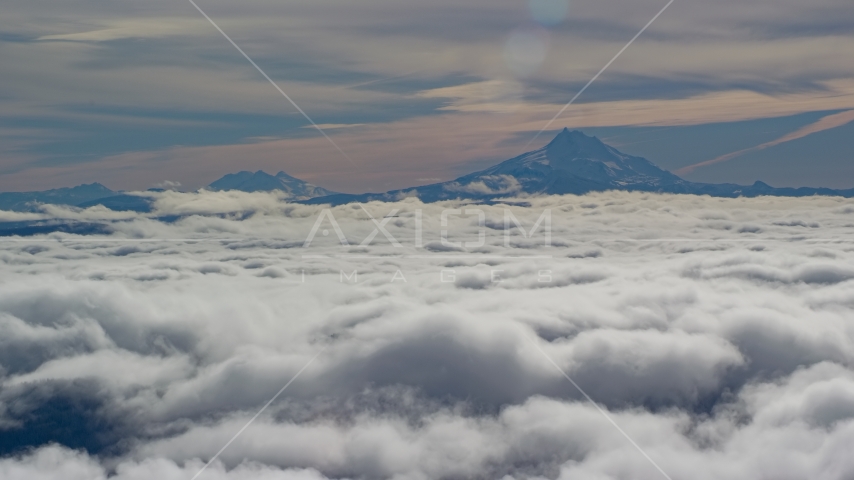 Mount Jefferson and the Three Sisters Volcanoes seen from across low clouds, Cascade Range, Oregon Aerial Stock Photo AX154_098.0000218F | Axiom Images