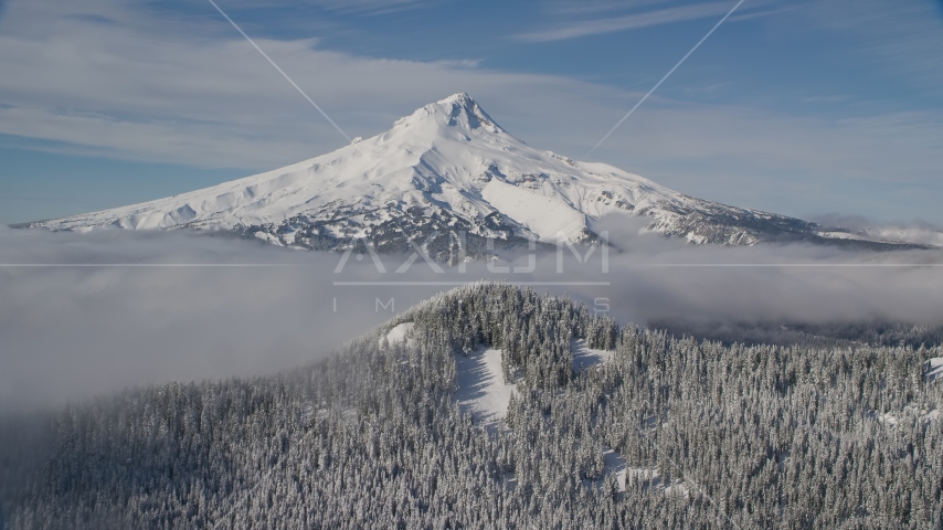 Mount Hood behind low clouds and a snow forest in the Cascade Range, Oregon Aerial Stock Photo AX154_112.0000331F | Axiom Images