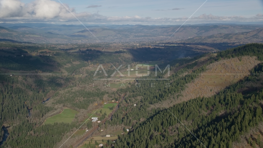 Farms and evergreen forest in a canyon, Hood River, Oregon Aerial Stock Photo AX154_148.0000145F | Axiom Images