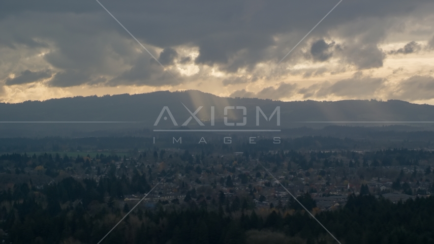 Cascade Range and godrays shining from clouds seen from suburban neighborhood, Beaverton, Oregon Aerial Stock Photo AX155_007.0000000F | Axiom Images