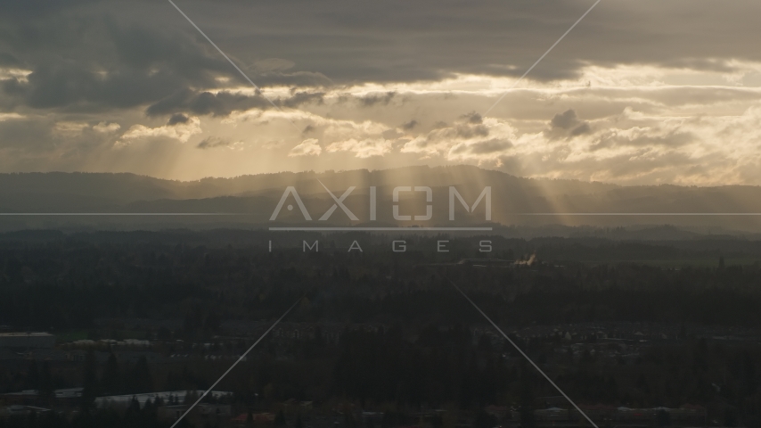 Distant mountains and godrays from the clouds near Beaverton, Oregon, at sunset Aerial Stock Photo AX155_125.0000111F | Axiom Images