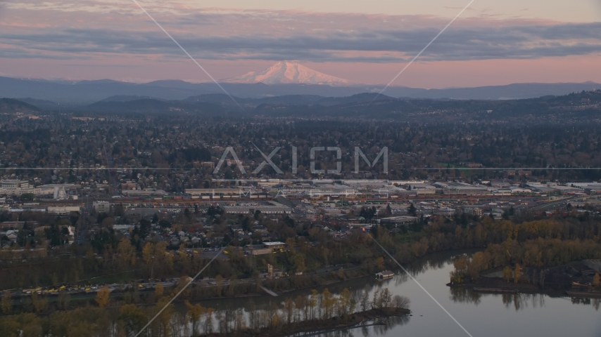 Mount Hood in the far distance at sunset, seen from a train yard in Southeast Portland, Oregon Aerial Stock Photo AX155_169.0000000F | Axiom Images