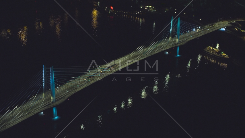 Tilikum Crossing bridge as a commuter train crosses the span at night in South Portland, Oregon Aerial Stock Photo AX155_416.0000264F | Axiom Images