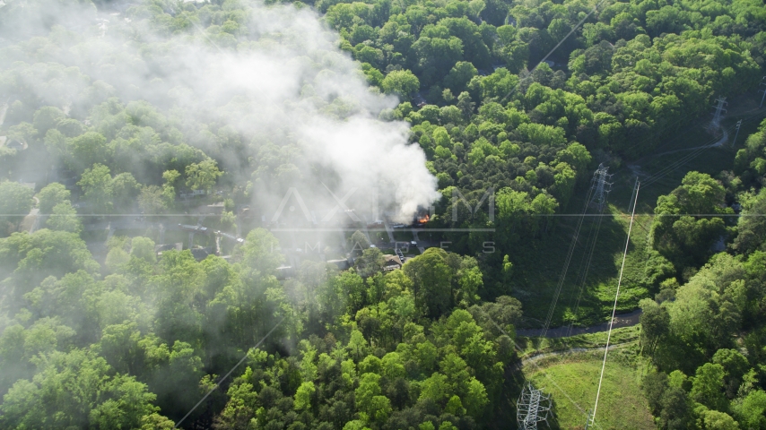 Smoke rising from a burning house in a wooded area, West Atlanta, Georgia Aerial Stock Photo AX38_049.0000254F | Axiom Images