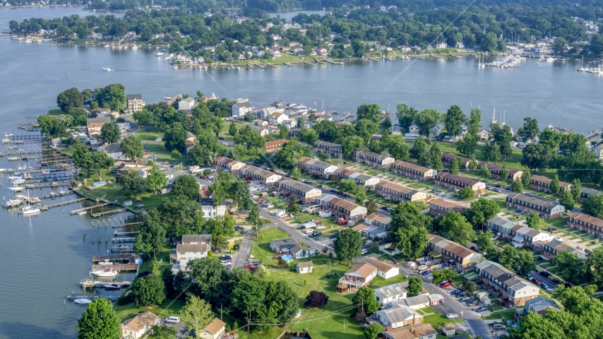Row houses and riverfront homes with docks by Dark Head Creek and Middle River in Middle River, Maryland Aerial Stock Photo AXP073_000_0007F | Axiom Images