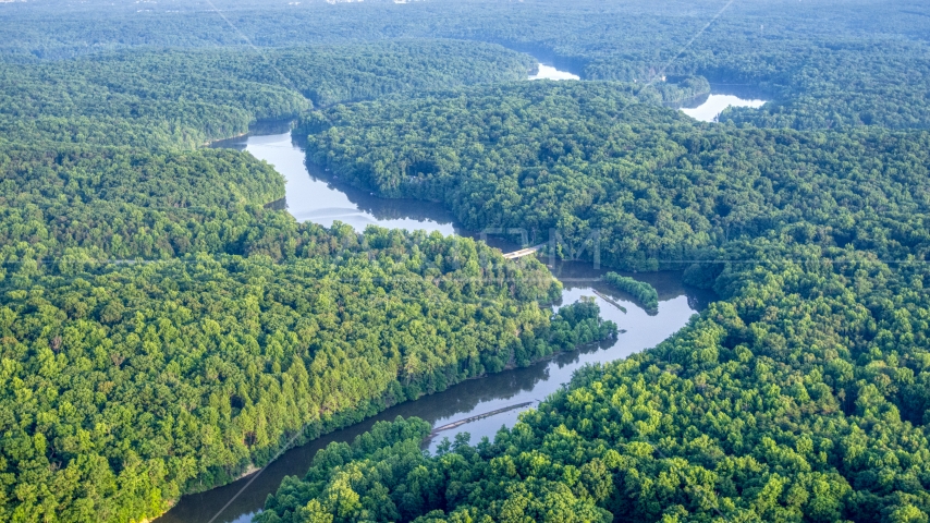 A bridge spanning a river through dense forest near Manassas, Virginia Aerial Stock Photo AXP075_000_0028F | Axiom Images