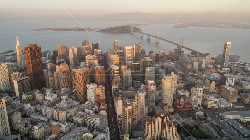 Downtown San Francisco skyscrapers and views of San Francisco Bay and Bay Bridge, California, sunset Aerial Stock Photo DCSF10_012.0000356 | Axiom Images