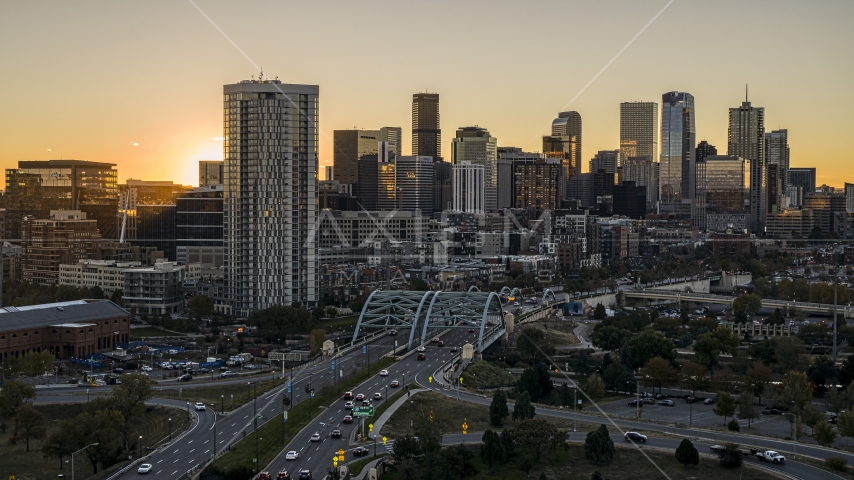 The city's skyline behind a residential skyscraper and a bridge at sunrise in Downtown Denver, Colorado Aerial Stock Photo DXP001_000090 | Axiom Images