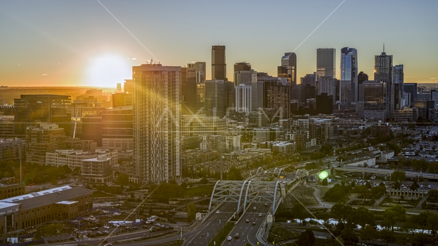 The rising sun behind the city's skyline and a residential skyscraper in Downtown Denver, Colorado Aerial Stock Photo DXP001_000091 | Axiom Images
