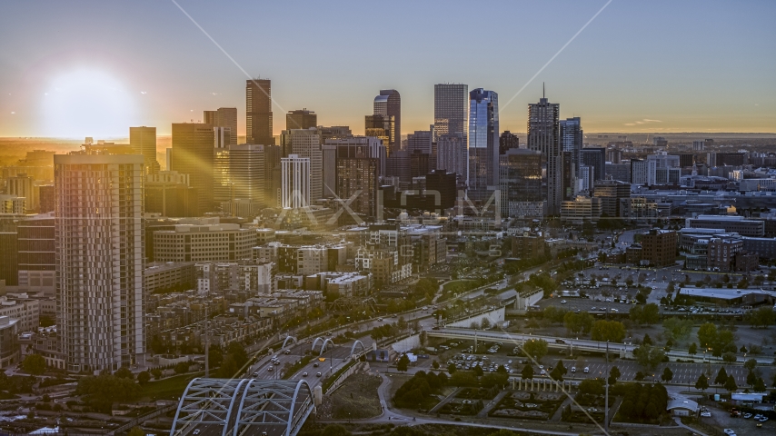 Sun rising behind the city's skyline and a residential skyscraper in Downtown Denver, Colorado Aerial Stock Photo DXP001_000095 | Axiom Images