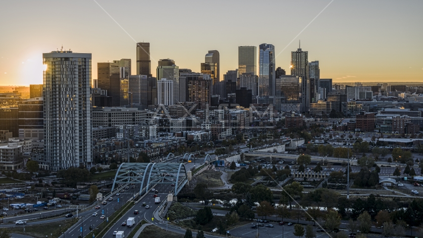 Sun rising behind residential skyscraper and city's skyline in Downtown Denver, Colorado Aerial Stock Photo DXP001_000096 | Axiom Images
