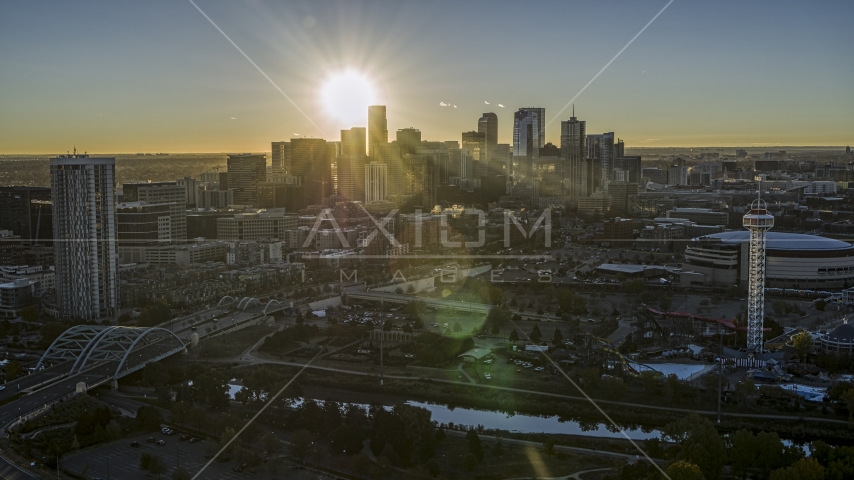 The sun shining behind the skyscrapers of the city's skyline at sunrise in Downtown Denver, Colorado Aerial Stock Photo DXP001_000105 | Axiom Images