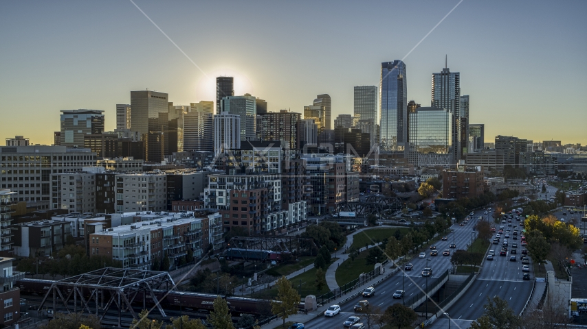 Skyscrapers of the city's skyline at sunrise, viewed from a park and busy street in Downtown Denver, Colorado Aerial Stock Photo DXP001_000110 | Axiom Images