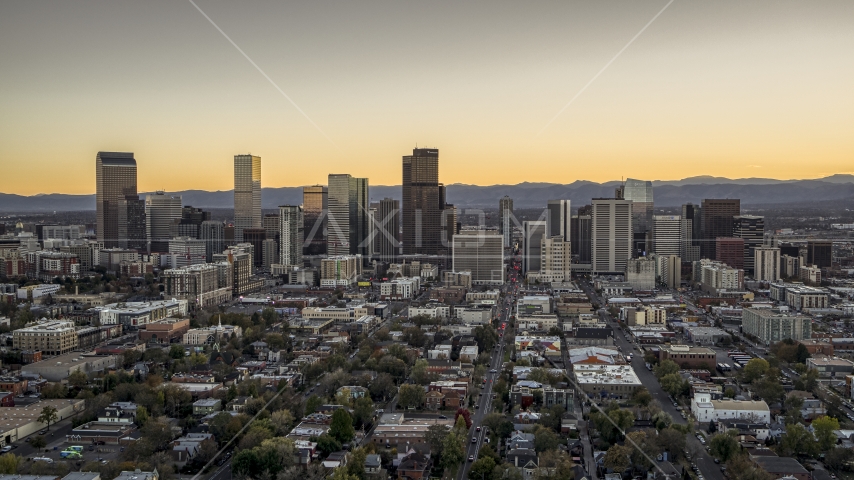 Wide view of skyscrapers in the city's downtown skyline at sunset, mountains in background, Downtown Denver, Colorado Aerial Stock Photo DXP001_000185 | Axiom Images