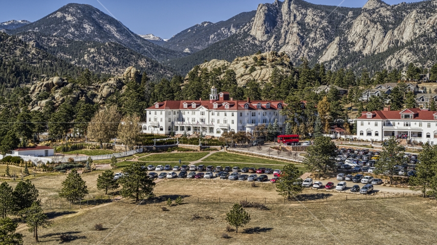 The historic Stanley Hotel with mountains behind it in Estes Park, Colorado Aerial Stock Photo DXP001_000208 | Axiom Images