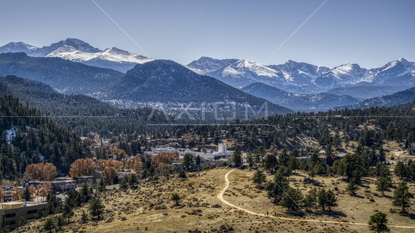 A small town and giant, snowy mountains in Estes Park, Colorado Aerial Stock Photo DXP001_000214 | Axiom Images