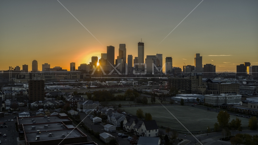 The sun peeking out between skyscrapers in the city's skyline at sunrise in Downtown Minneapolis, Minnesota Aerial Stock Photo DXP001_000255 | Axiom Images
