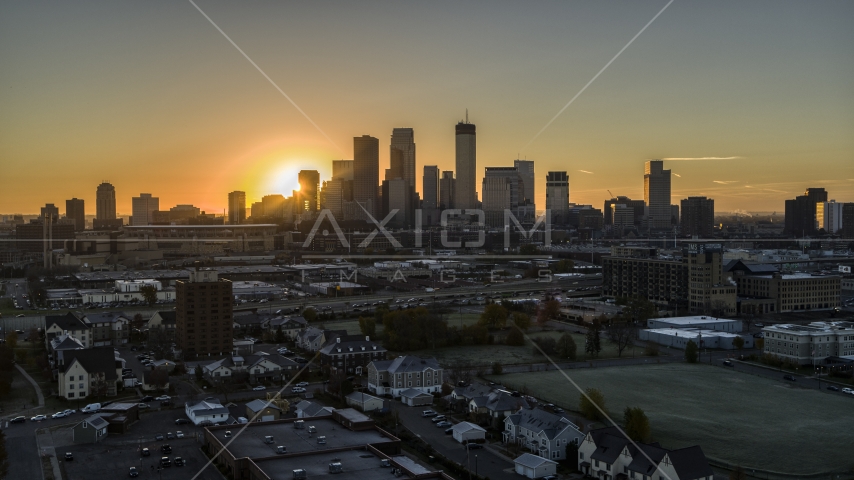 The sun behind skyscrapers in the city's skyline at sunrise in Downtown Minneapolis, Minnesota Aerial Stock Photo DXP001_000256 | Axiom Images