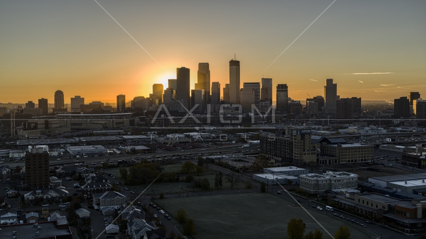 The sun behind tall skyscrapers in the city's skyline at sunrise in Downtown Minneapolis, Minnesota Aerial Stock Photo DXP001_000257 | Axiom Images
